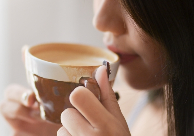 woman sipping from a cup