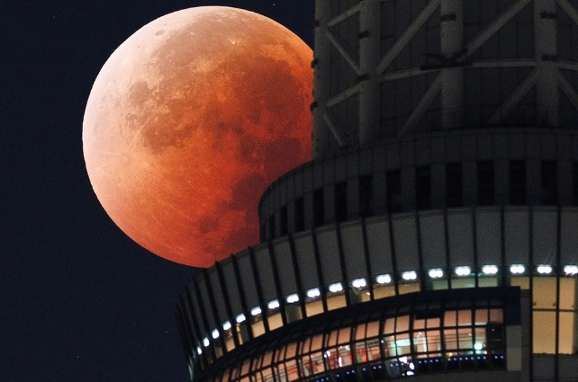The Moon appears from behind the Tokyo Skytree