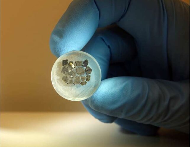 Tiny crystals held by a gloved hand