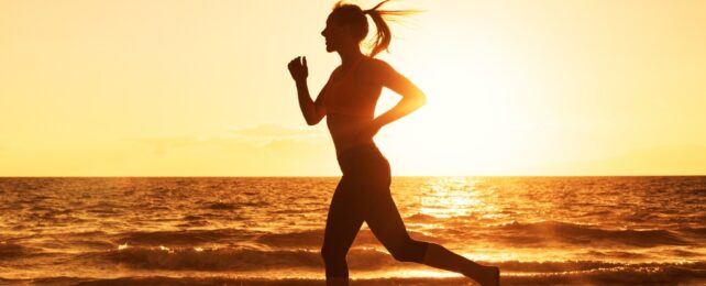 silhouette of a woman running on a beach