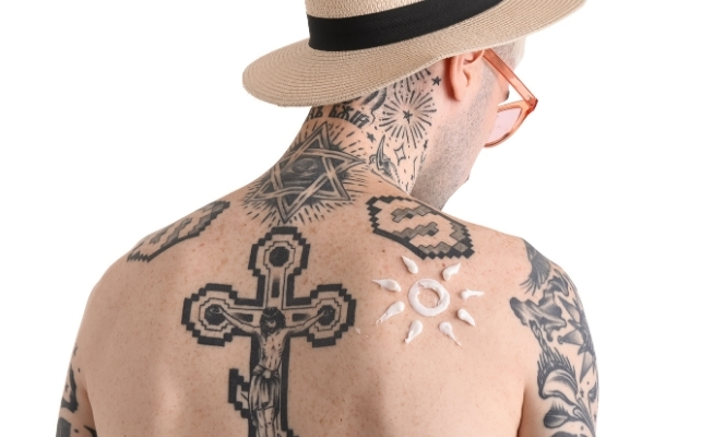 man with tattoos and sunscreen