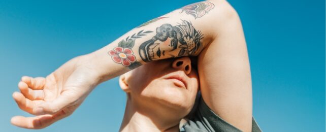 person with tattoos in the sun