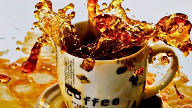 Coffee spilling out of a cup and splashing everywhere