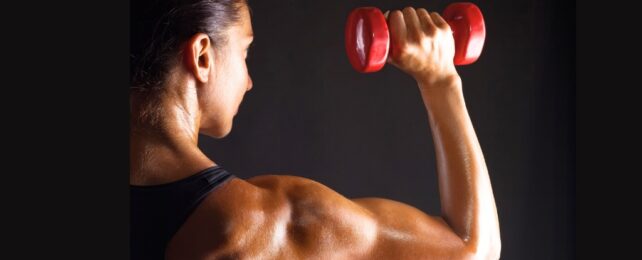 A woman facing away, lifting a red dumbbell