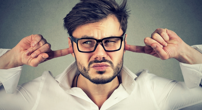 man with fingers in ears