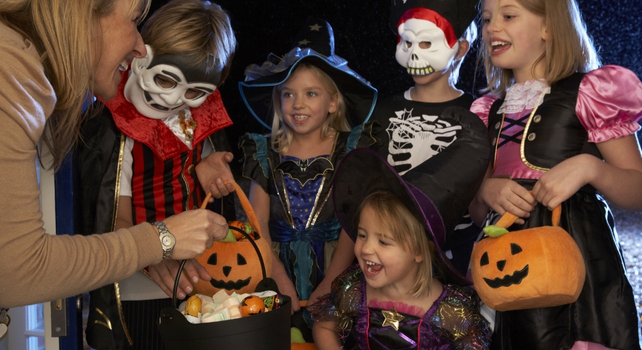 children in costume receiving sweets