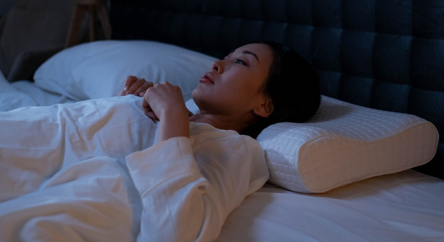 woman laying awake in bed
