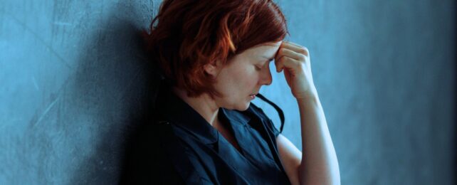 woman depressed against a concrete wall
