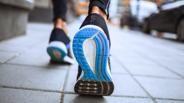 Blue soles of shoes, walking away from viewer