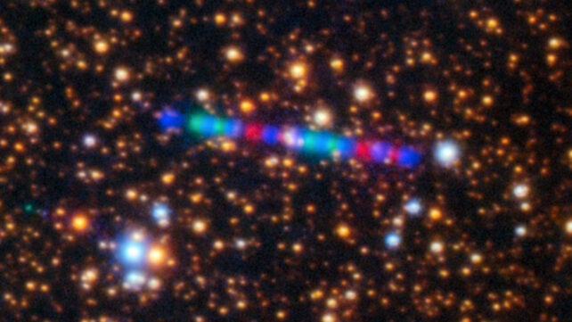 Comet 3IATLAS streaks across a dense star field, in an image composed of exposures taken through three filters, shown here as red, green, and blue.