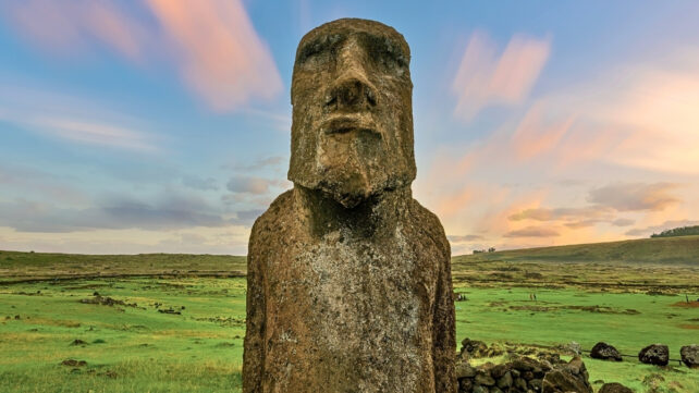 Close up of Rapa Nui's (Easter Island's) Moai statue in front of colorful sky