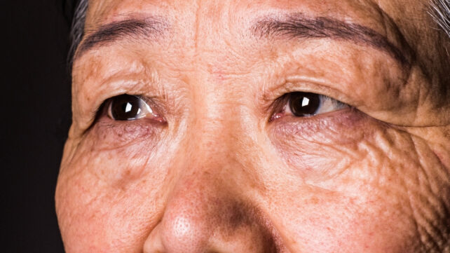 Close up of an older asian woman's eyes. gazing off to the side slightly