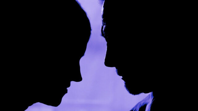 Silhouette of a couple's faces, appearing to be talking close to each other on a purple background