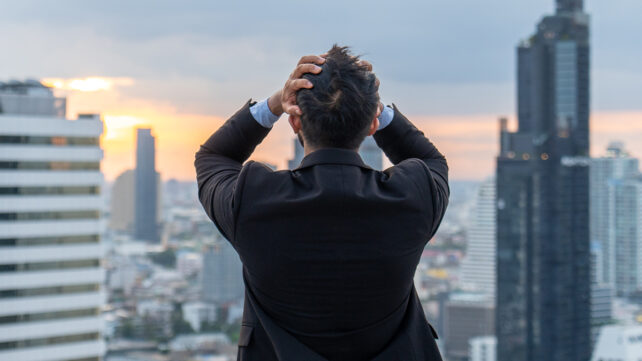 Businessman standing on rooftop in city after work