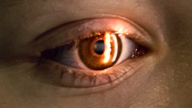 Close zoom of an eye undergoing a visual field test, with light shining into the iris.