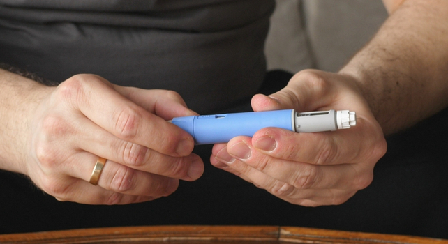 male hands holding a semaglutide pen