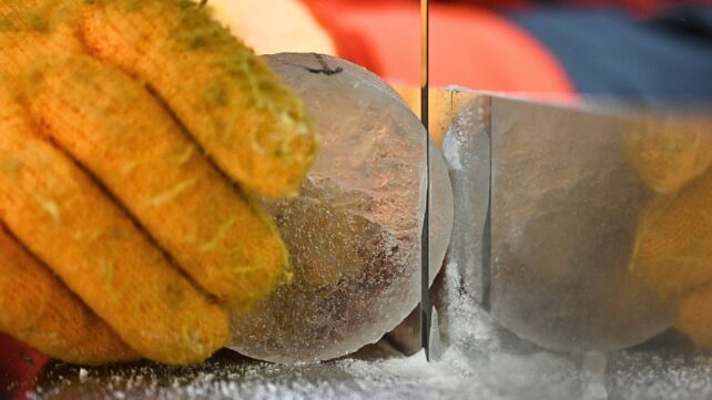 high contrast close up of gloved hand holding ice core