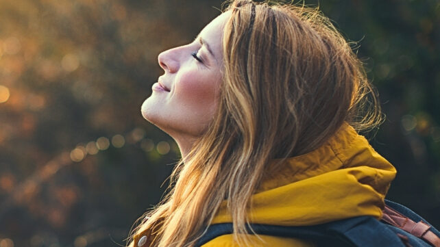 woman standing outside with eyes closed