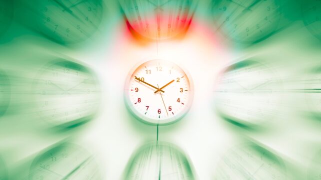 A central clock in focus surrounded by blurred clocks