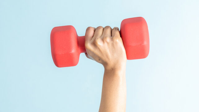 A young black woman lifting a dumbbell on a blue background