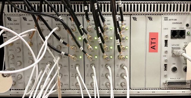 a silver machine has many wires plugged into it. 