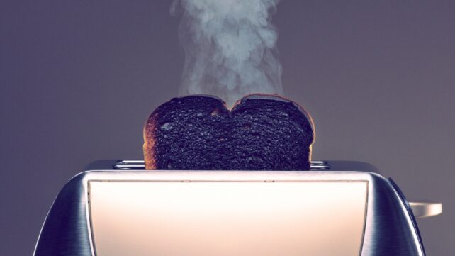 Toaster with one slice of smoking burned toast