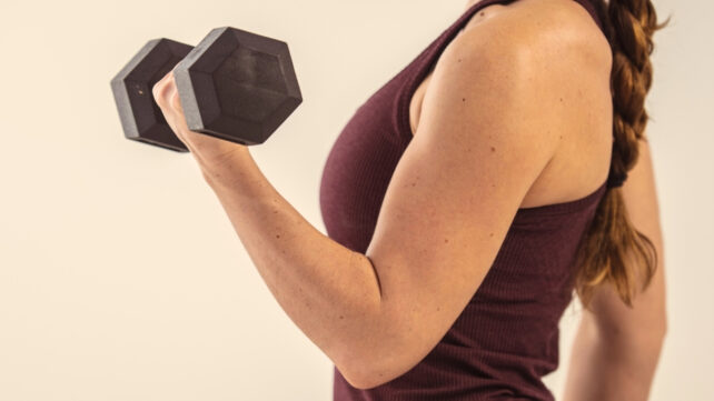 woman's arm flexing while holding weight