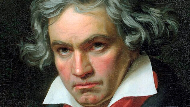 High resolution image of a portrait of Beethoven with greying hair against a dark background