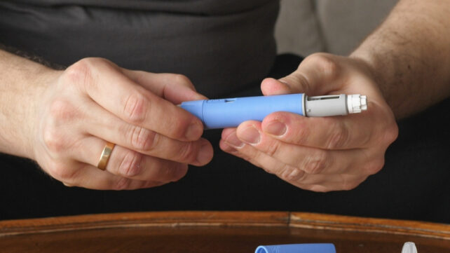 close up of a semaglutide injection pen in man's hands