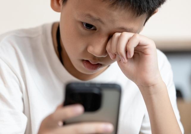 tired child with a phone