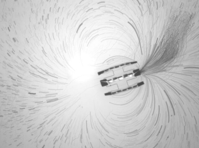 A rectangular robot with dark edges generates a flow of fluid molecules around itself, in an arc. 