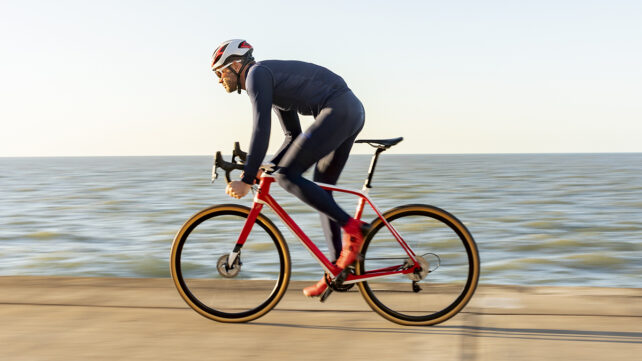 A man cycling near the sea