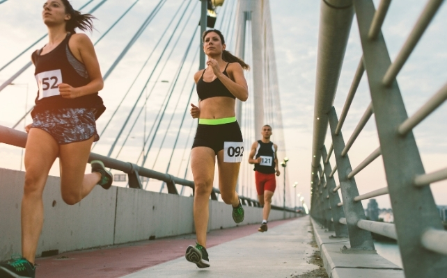 marathon runners on a bridge