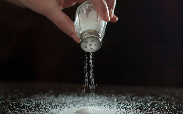 salt pouring onto a surface against a black background