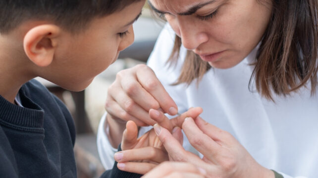 mother removing a splinter from her child's finger