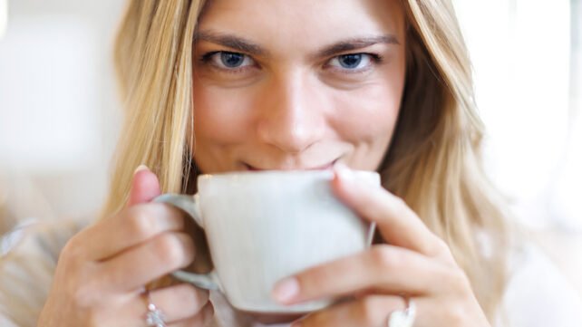 A close-up shot of a woman enjoying a cup of coffee