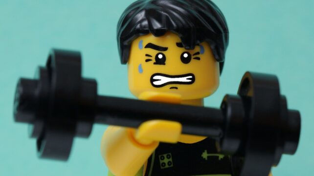 LEGO person lifting weights and grimacing