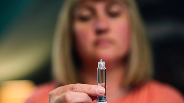 woman holds injector