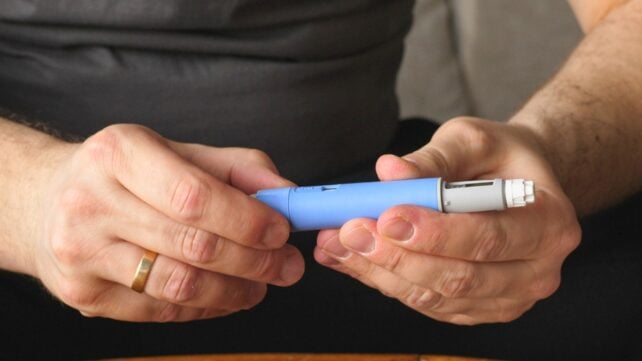 Hands holding a semaglutide pen