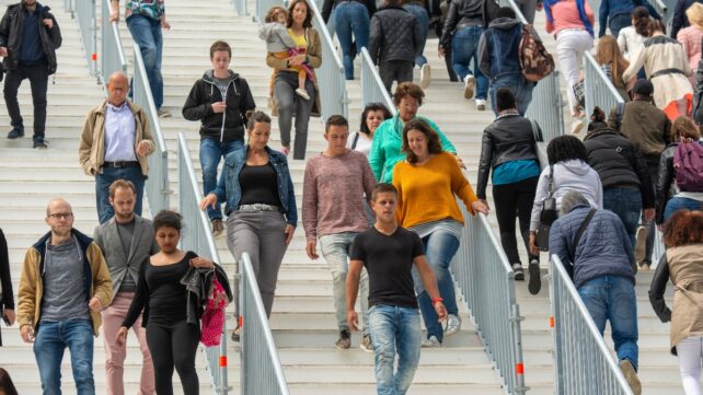 People walk up and down stairs in a busy urban public space