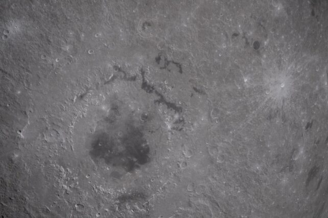A super close up image of the Moon's surface, with a clear view of an impact crater
