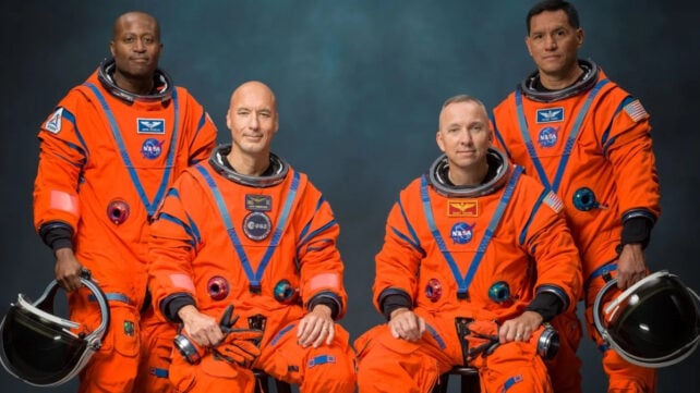 The Artemis III crew poses in orange spacesuits for an official portrait