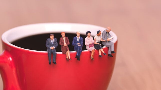 Miniature people on a coffee cup