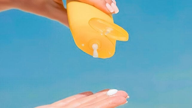 Applying sunscreen on hands outdoors