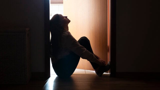 Teenager sitting in a doorway