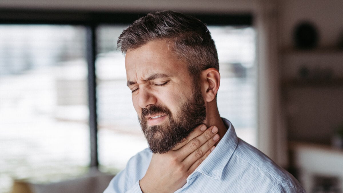 A man feeling his throat
