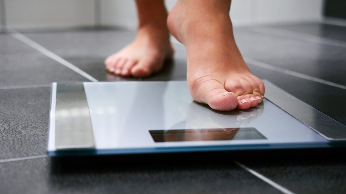 Person stepping onto a weighing scale