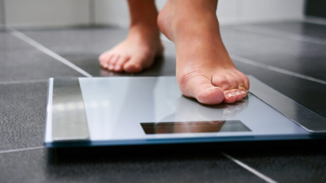 Person stepping onto a weighing scale