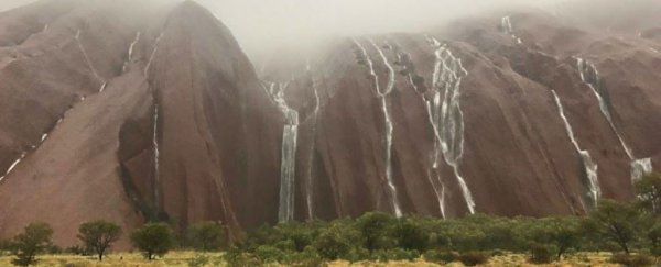 Uluru became a massive waterfall after extreme rains flooded the Australian desert
